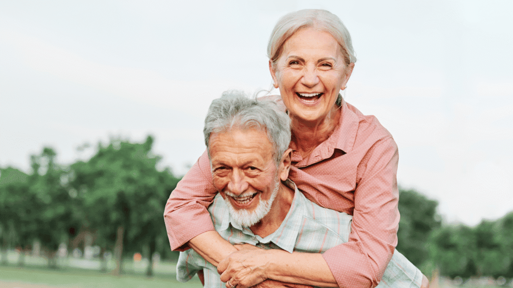 Pareja de adultos mayores sonriendo al aire libre tras comparar planes de Medicare