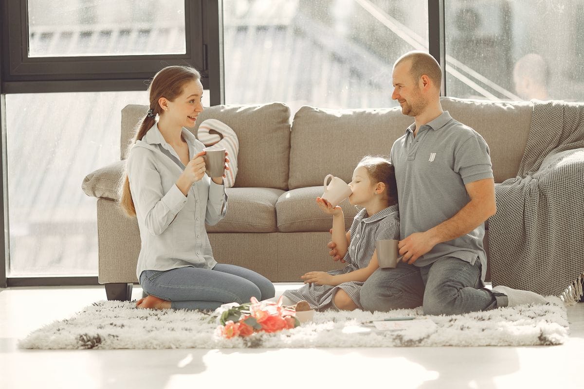 Madre y padre disfrutando en casa con sus hijos, protegidos por un seguro de vida