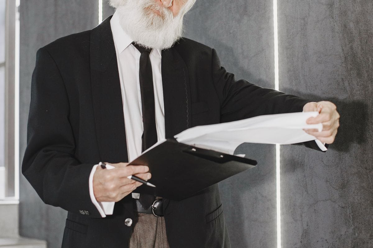 Hombre de 65 anos revisando documentos mientras coordina Medicare con el seguro de su empleo