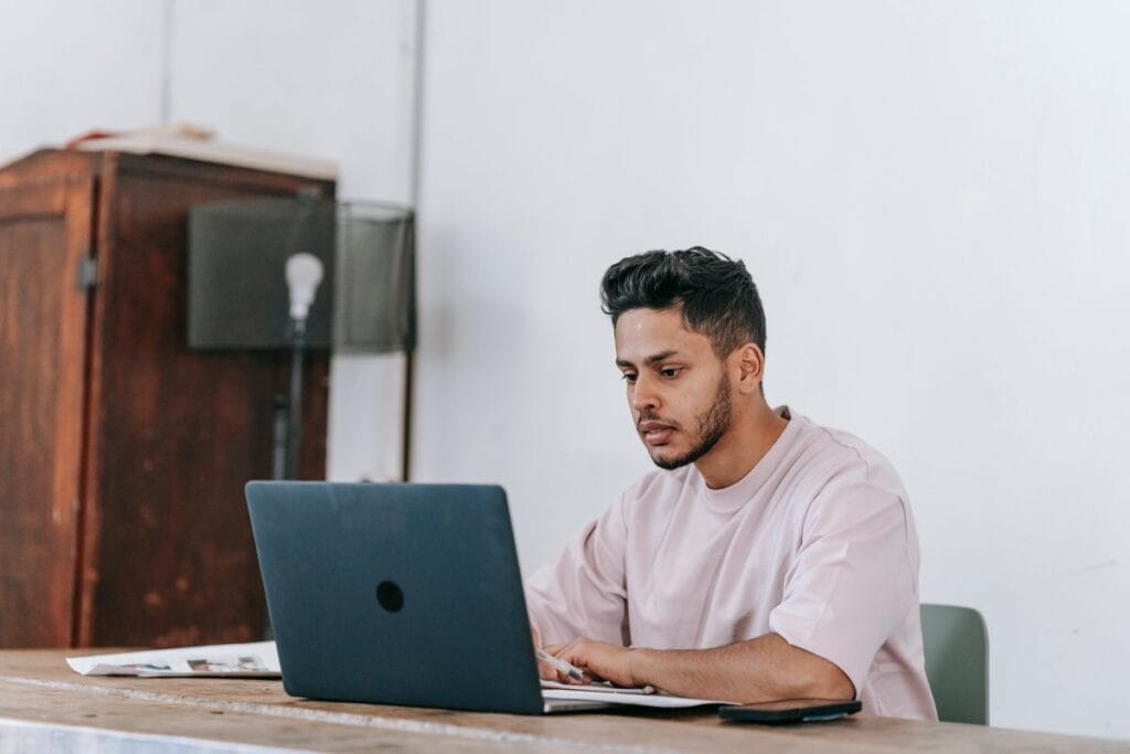 Trabajador por cuenta propia revisando su seguro de salud en una laptop en casa